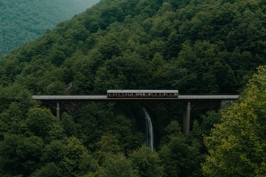 A train crossing a bridge over a waterfall in the mountains photo