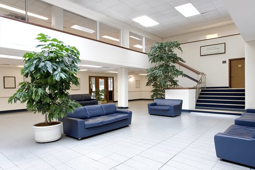 A large lobby with a staircase and a plant photo