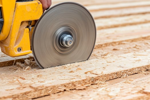 A person using a circular saw to cut wood photo