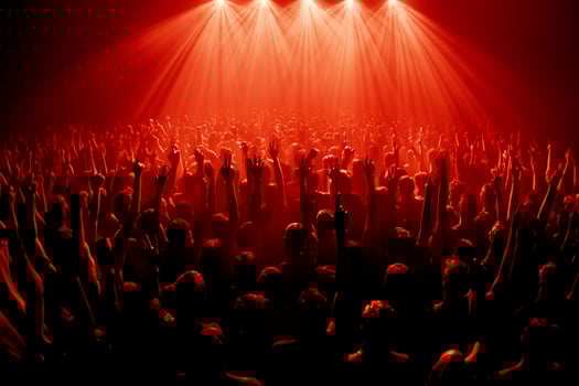 A crowd of people at a concert with red lights photo