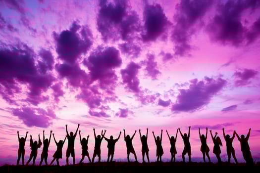 A group of people standing on a hill with their arms up photo