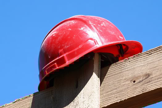 A red hard hat on a wooden beam photo