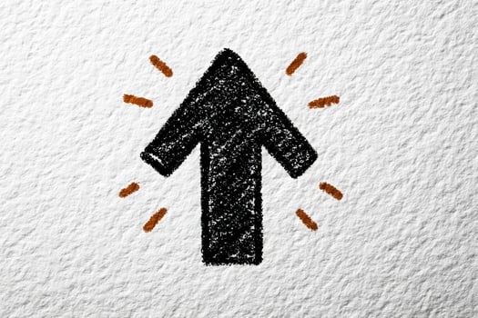 A bold upward arrow is drawn in black against a textured white background, surrounded by energetic orange accents. The design conveys a sense of direction and positivity. photo