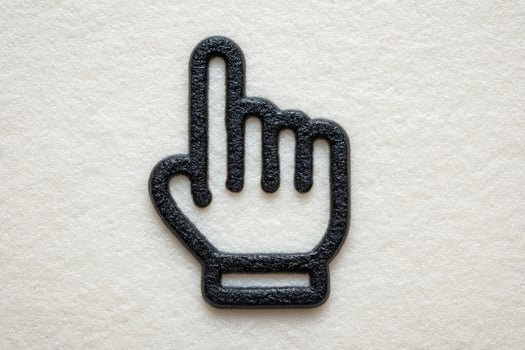 A textured surface features a black hand gesture symbol, specifically an index finger pointing upwards, indicating stop or attention. The design emphasizes simplicity and clarity. photo