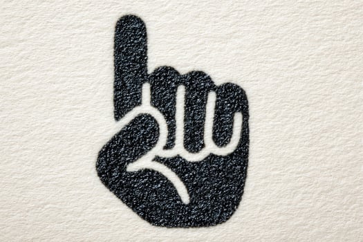 A hand is depicted with one finger raised, indicating silence or a warning gesture. The design features a textured background that enhances the visual appeal. photo