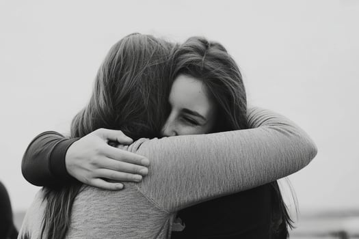 Two women hugging on the beach photo