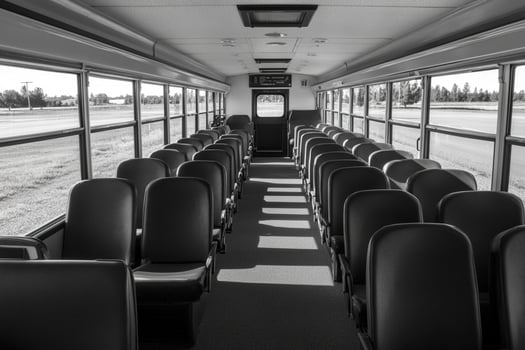 A black and white photo of empty seats on a bus