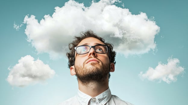 A man with glasses looking up at a cloud in the sky. photo