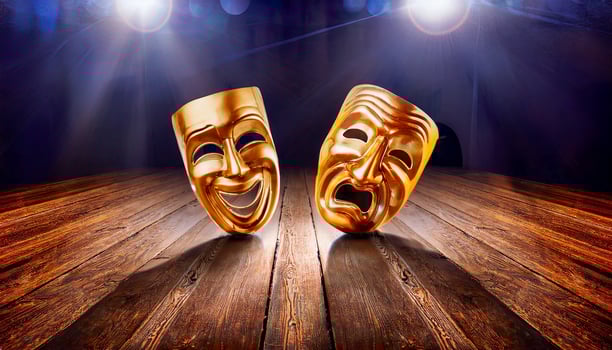 On the wooden stage lie two shining masks one of joy, one of despair - capturing the eternal contrast of human feeling that lives in every performance. photo