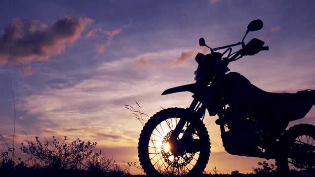 A motorcycle is silhouetted against the sunset photo