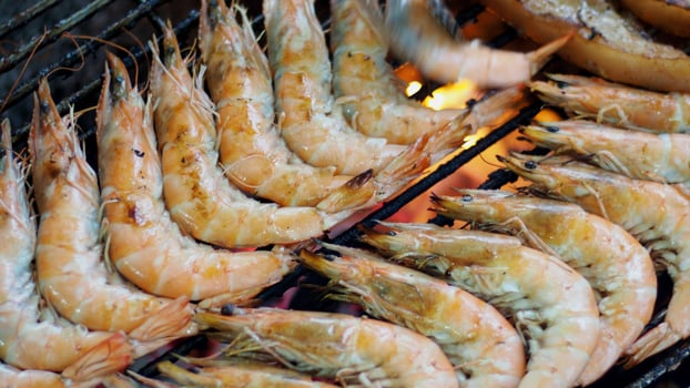 A grill with shrimp cooking on it photo