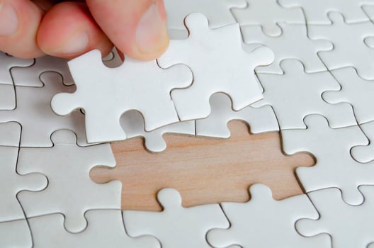 Hand placing missing jigsaw puzzle pieces. Solution concept photo