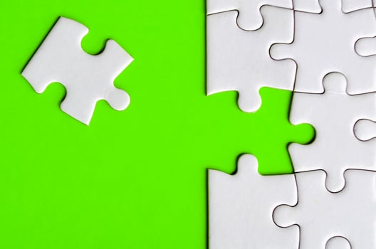 Connecting missing white jigsaw puzzle symbolizes partnership and unity on green background photo