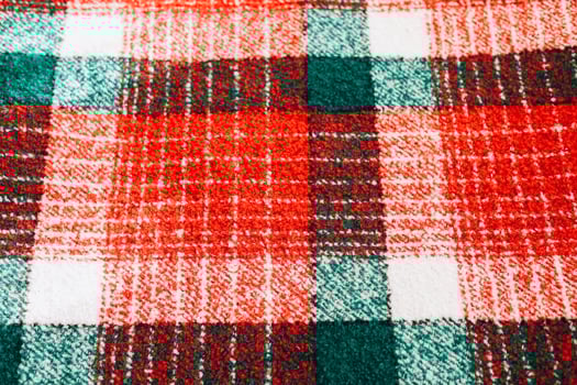 Colorful plaid fabric with red and green checkered pattern on a soft surface photo