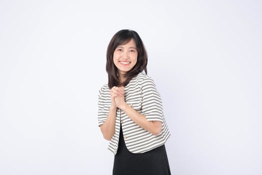 Asian woman smiling with hands clasped, striped jacket, black dress, cheerful expression, white background, positive mood photo