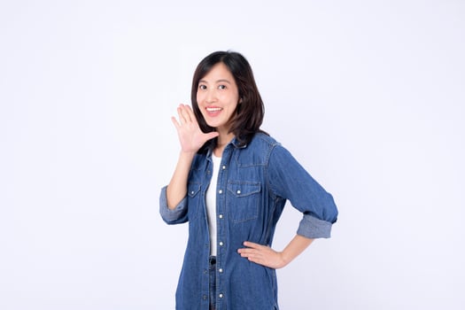 Asian woman denim jacket white background smiling shouting gesture casual cheerful hand on hip young adult portrait photo