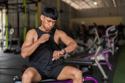 Fitness Enthusiast man in a gym Checking Smartwatch During Workout photo