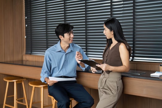 Business Collaboration and Communication. Two professionals discussing project details in a modern office. photo