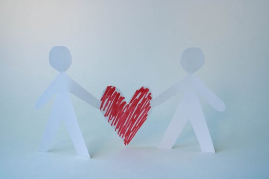 Two paper men are holding a red paper heart. The concept of love, Family Day, Mother's Day, Valentine's Day, March 8th photo