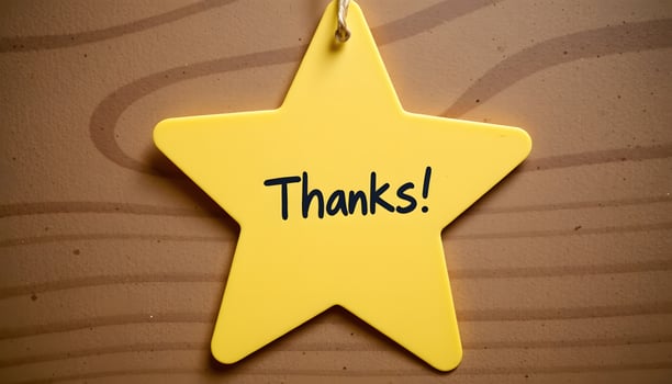 Yellow Star Shaped Thank You Note on Brown Wooden Background photo