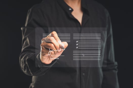 Close-up of a businessman uses a pen to sign electronic documents on a virtual screen while standing on a black background. photo