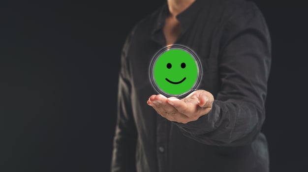 Positive feedback concept. Happy mood icon in hand while standing on a black background photo