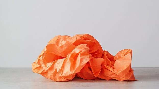 Crumpled orange paper on a gray surface photo