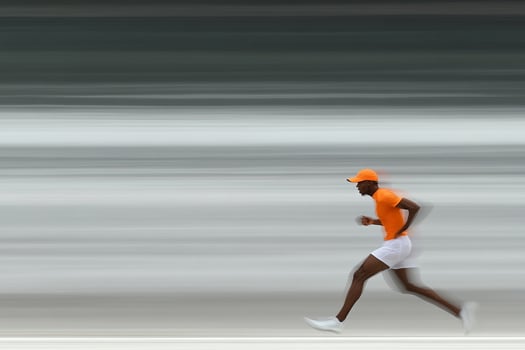 A man in an orange shirt and white shorts is running photo