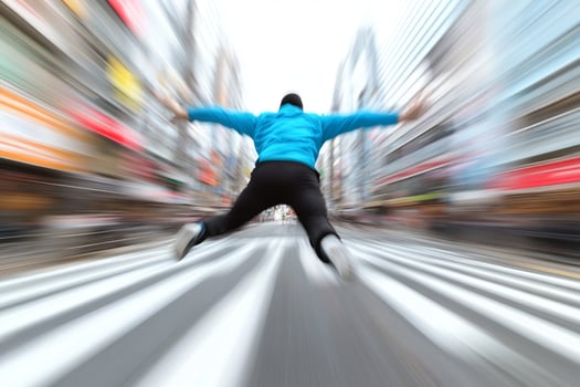 A man jumping over a busy street photo