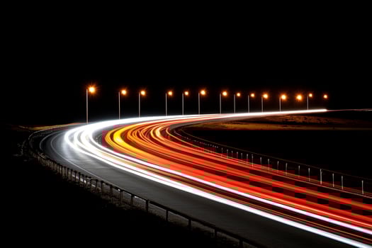 A long exposure photo of a highway at night