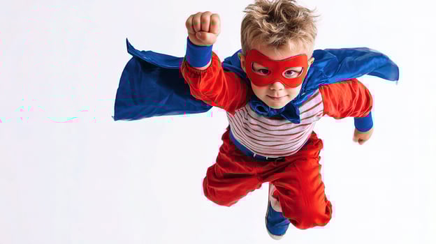 A young boy in a superhero costume flying through the air photo