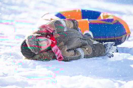 Happy little boy sledding on a snow slide Child in winter. photo