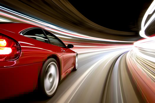 A red sports car driving on a highway at night photo