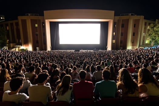 A large crowd of people watching a movie on a screen photo
