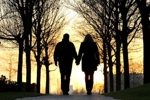 A couple walking down a path at sunset photo
