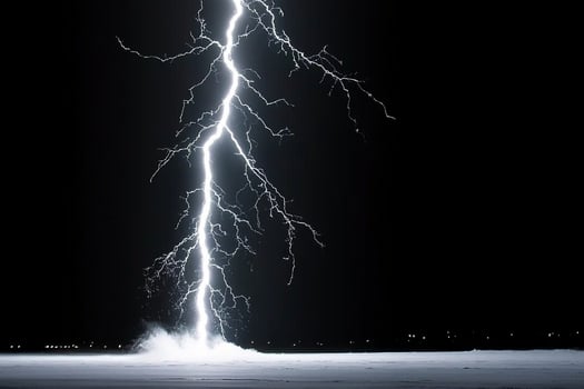 A lightning bolt is seen in the dark sky photo