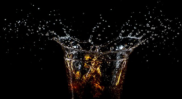 A glass of cola with a splash of water photo