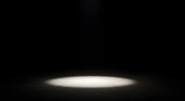 A spotlight shines on a dark floor photo