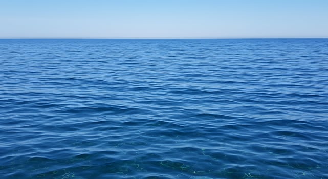 A large body of water with a blue sky photo