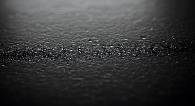 A black surface with a few small spots of water photo