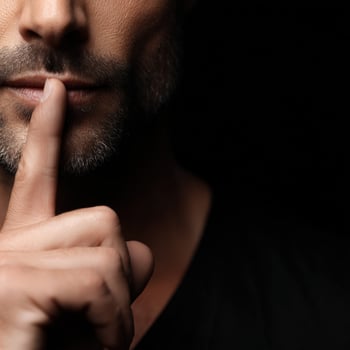 Man gestures for silence with a finger on his lips photo