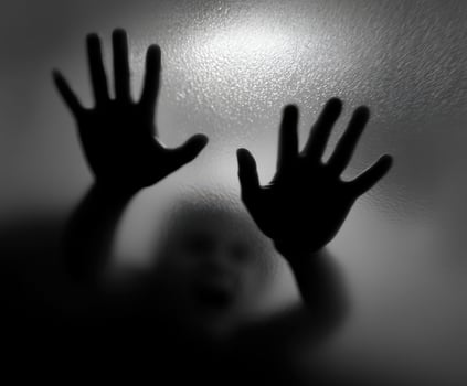 Child trapped behind a frosted glass door reaching out for help photo