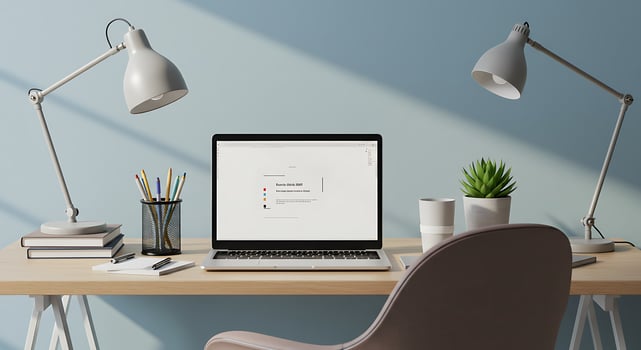 A laptop sitting on a desk with a lamp and a plant photo