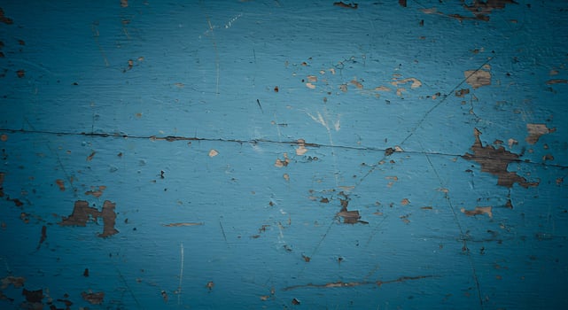 A blue wall with peeling paint and scratches photo