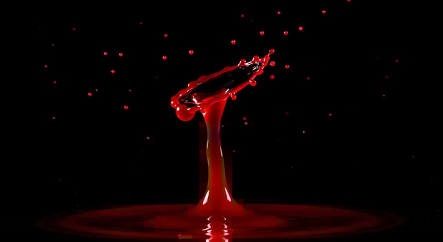 A red liquid dripping from a black surface photo