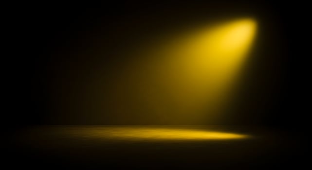 Yellow spotlight on a black background photo