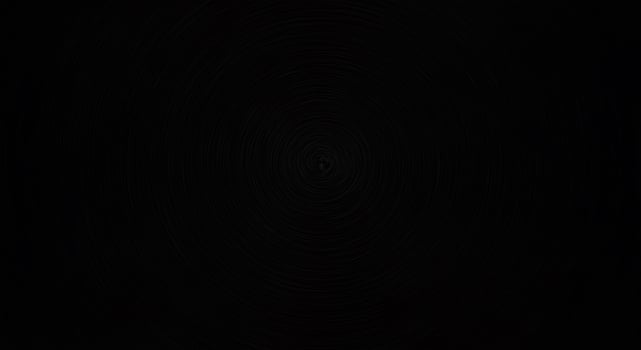 A black background with a circular pattern photo