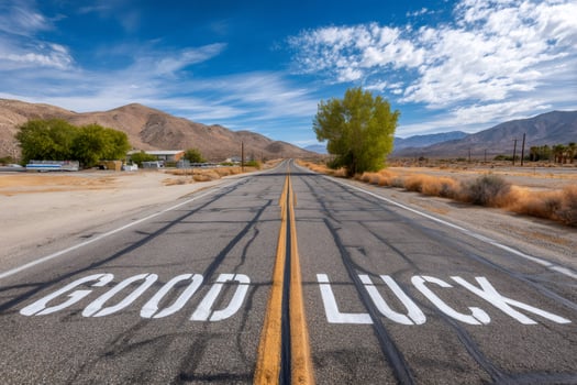Good luck sign painted on a desert road leading to mountains photo