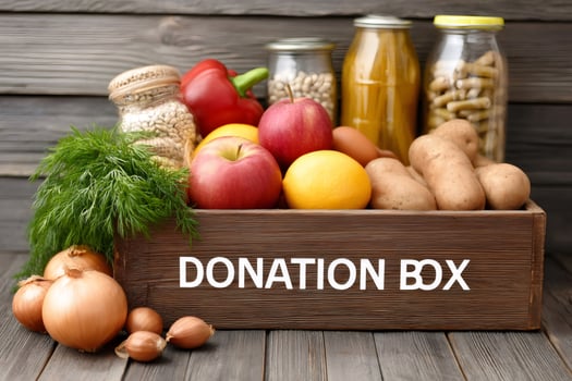 Donation box full of fresh food on wooden table photo