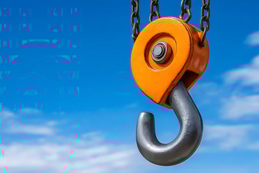 Crane hook hanging from chains on blue sky background photo